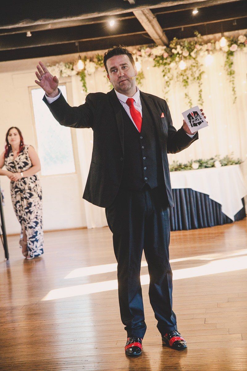 A man in a suit and tie is standing in a room with his arms outstretched.
