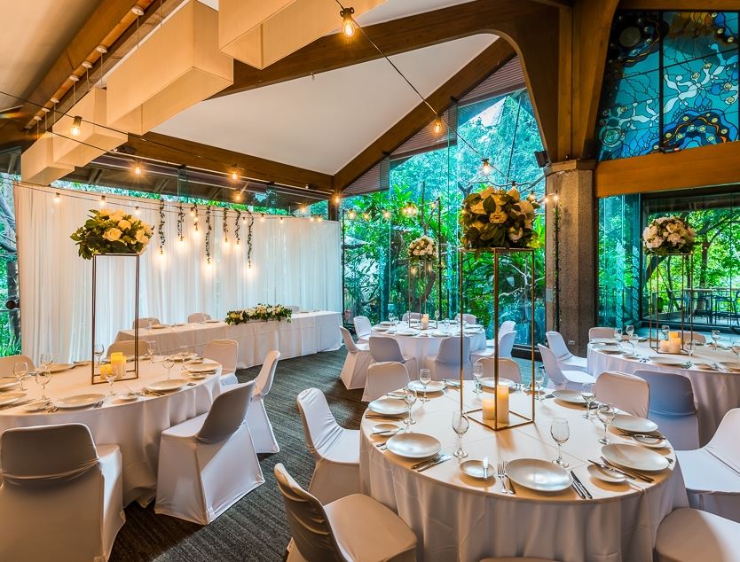 A large room with tables and chairs set up for a wedding reception.