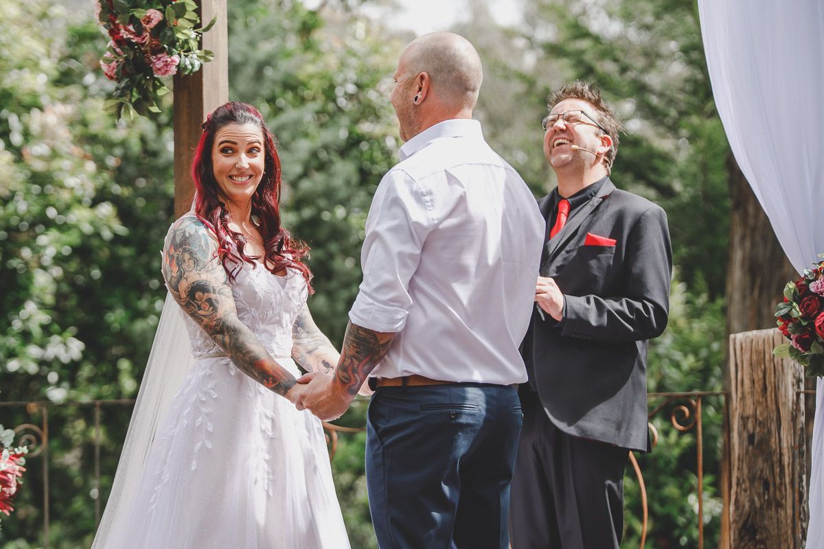 A bride and groom are holding hands during their wedding ceremony.
