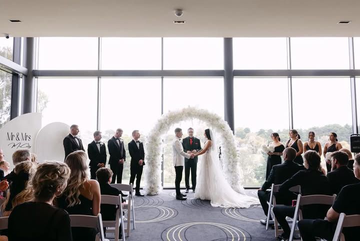 A bride and groom are holding hands during their wedding ceremony.