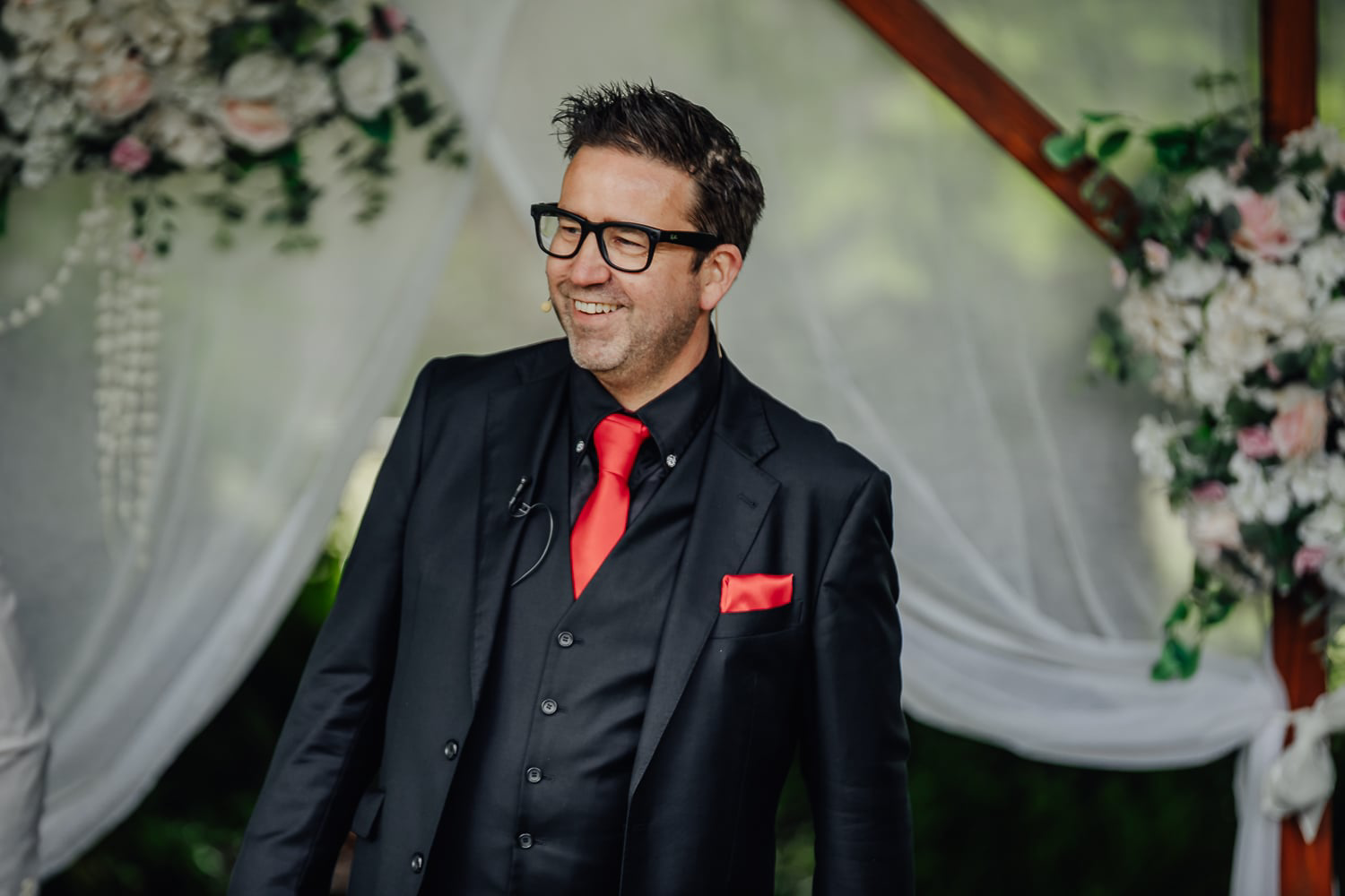 A man is giving a speech to a bride and groom at a wedding reception.