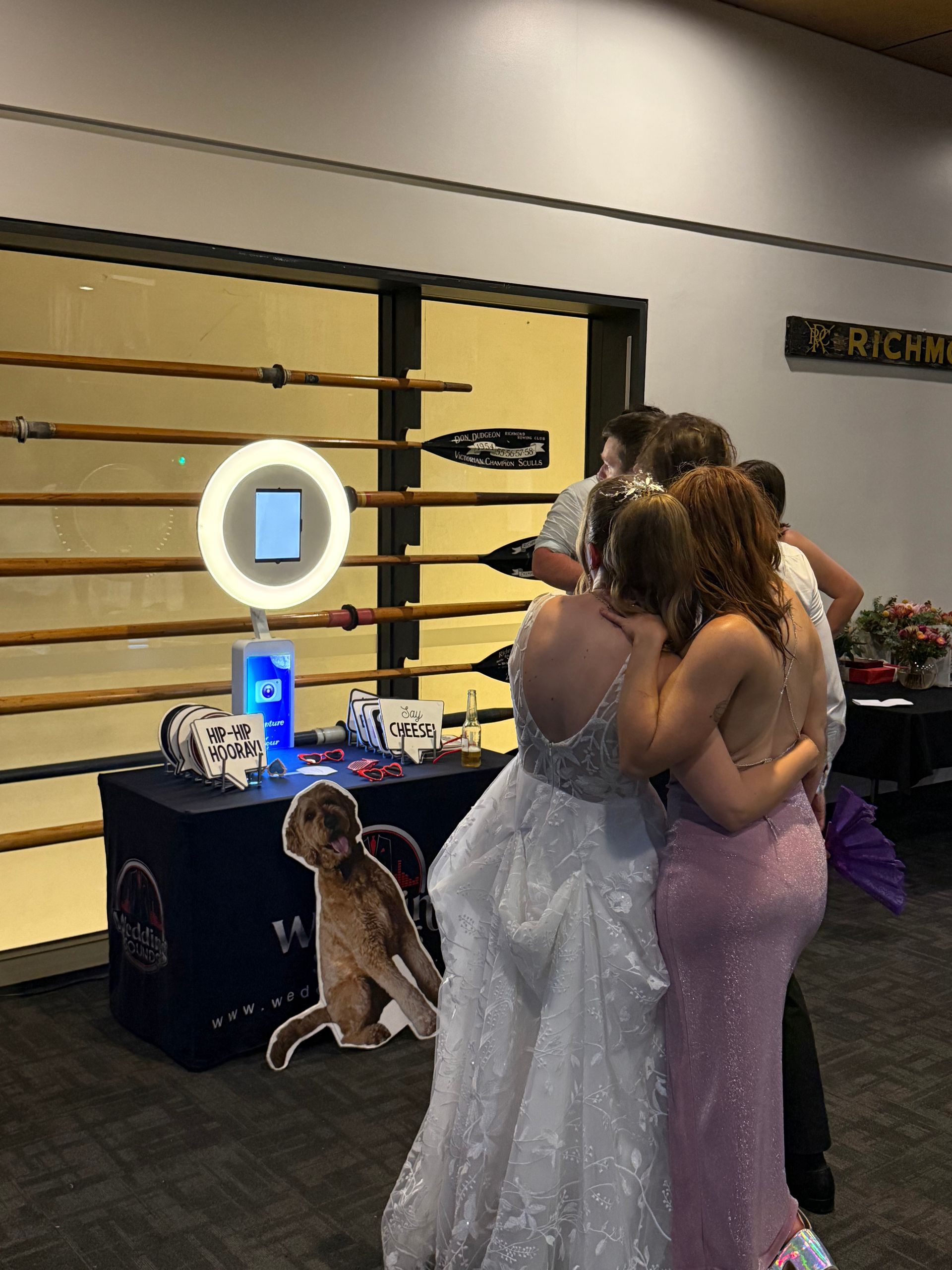A group of women are posing for a picture in front of a photo booth.