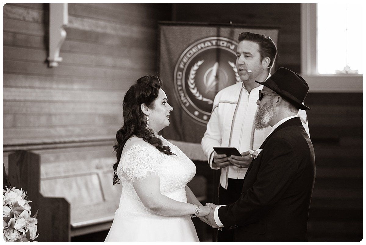 A bride and groom are holding hands during their wedding ceremony in a church.