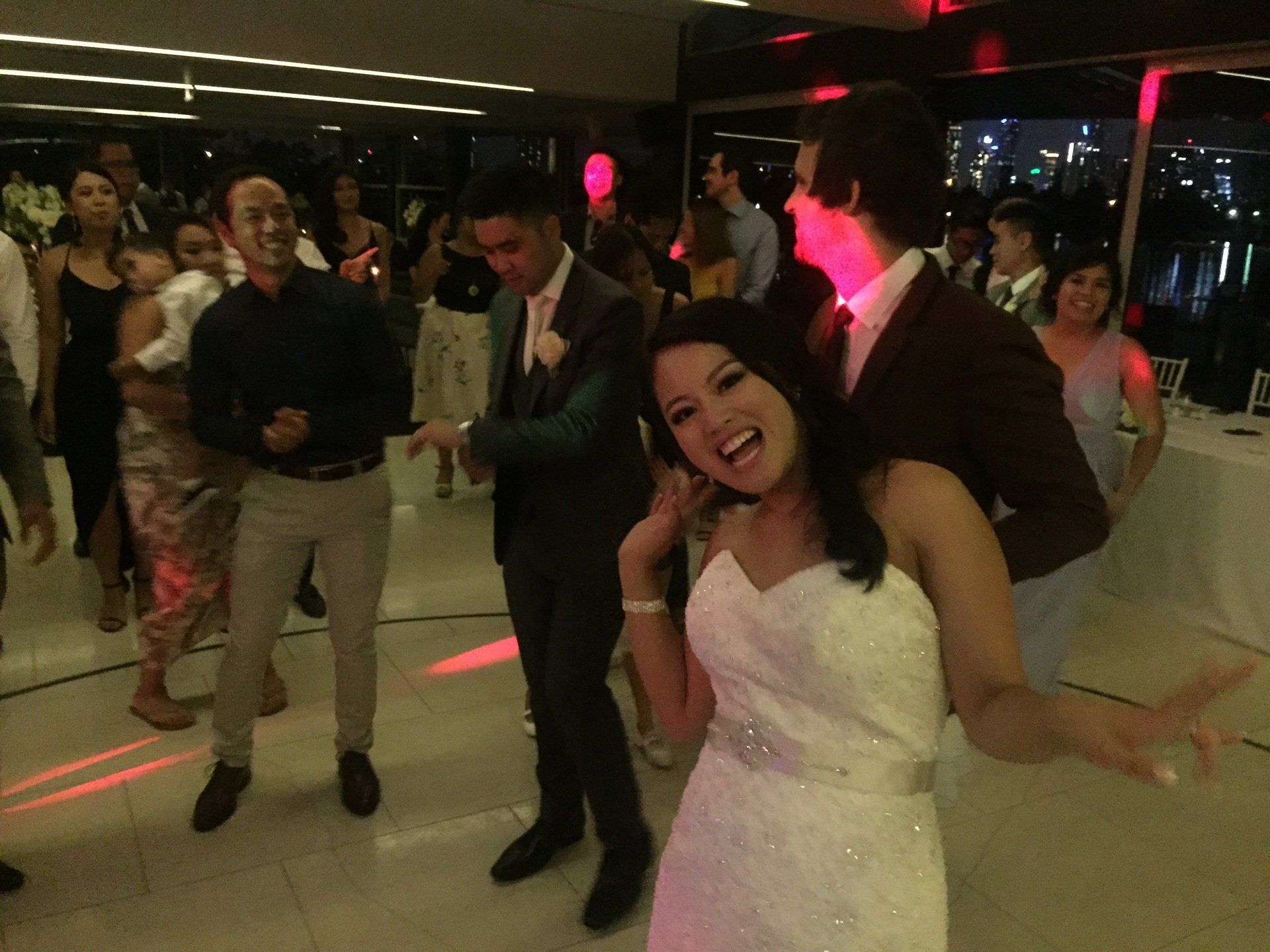 A bride and groom are dancing at a wedding reception