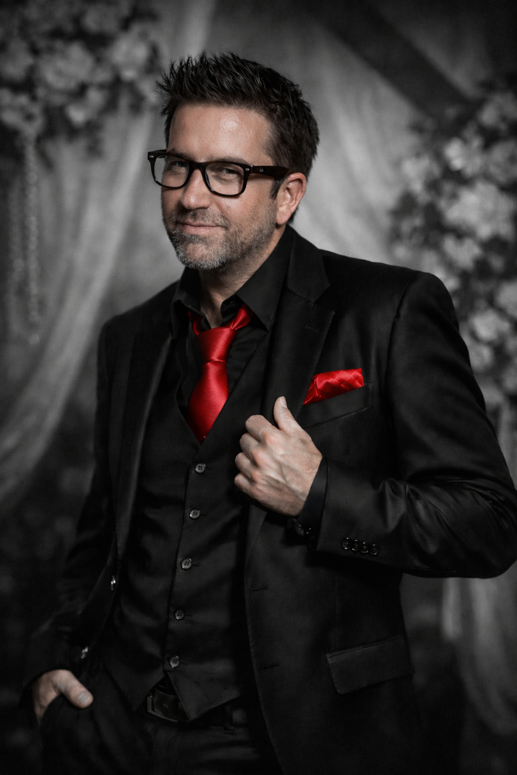 A man in a suit and tie is standing next to a brick wall.