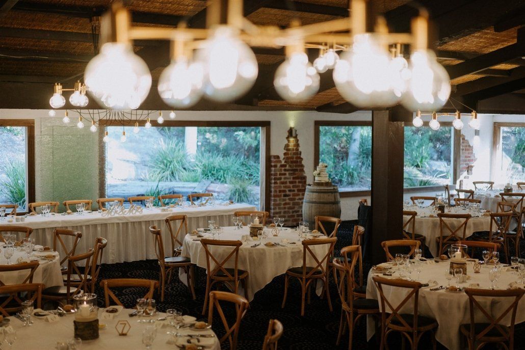A large dining room with tables and chairs set up for a wedding reception.