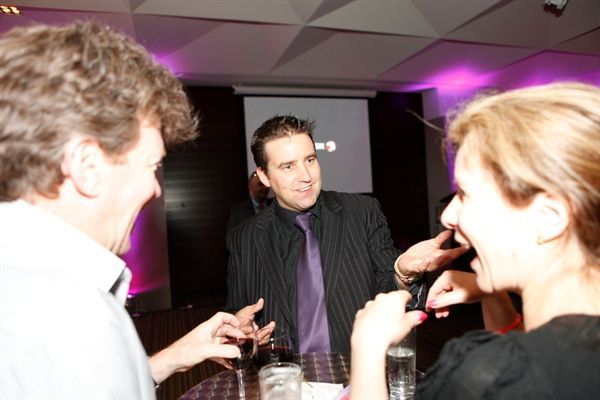 A man in a suit and tie is talking to two women