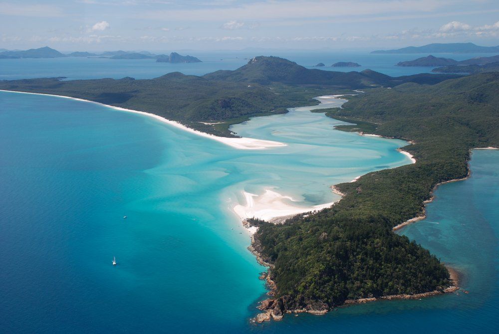 A View Of Island In The Middle Of A Large Body Of Water Surrounded By Mountains  — Blue Dog Hire Qld In Airlie Beach, QLD