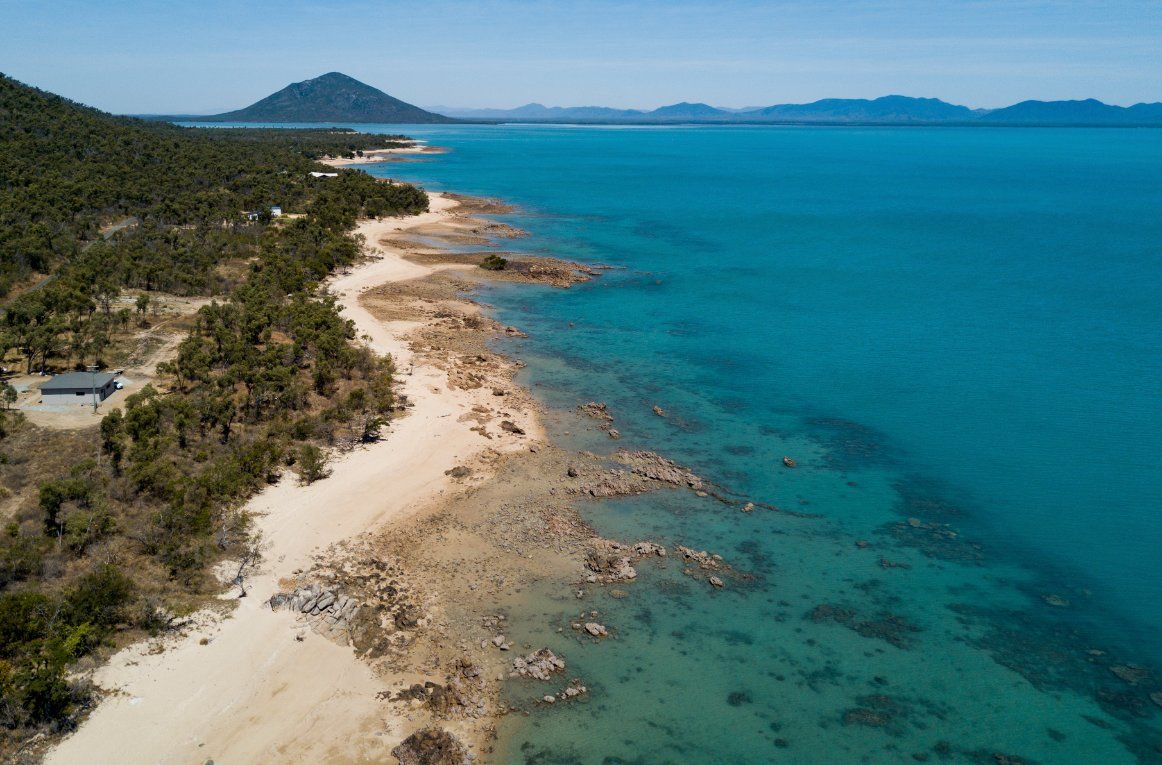 An Aerial View Of A Beach And A Large Body Of Water — Blue Dog Hire Qld In Airlie Beach, QLD