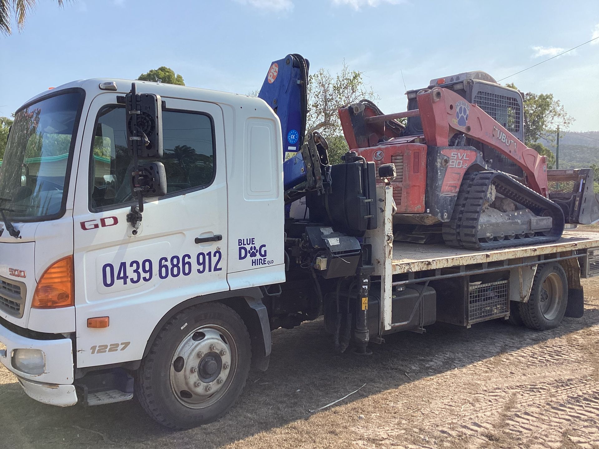 A White Truck With A Red Bobcat on the Back — Blue Dog Hire Qld In Midge Point, QLD