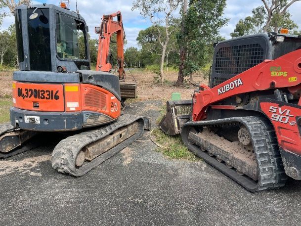 A Yellow And Black Construction Vehicle Is Parked In A Dirt Field — Blue Dog Hire Qld In Midge Point, QLD