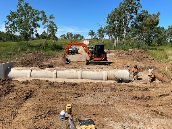 A Construction Site With A Bulldozer And Pipes In The Dirt — Blue Dog Hire Qld In Bowen