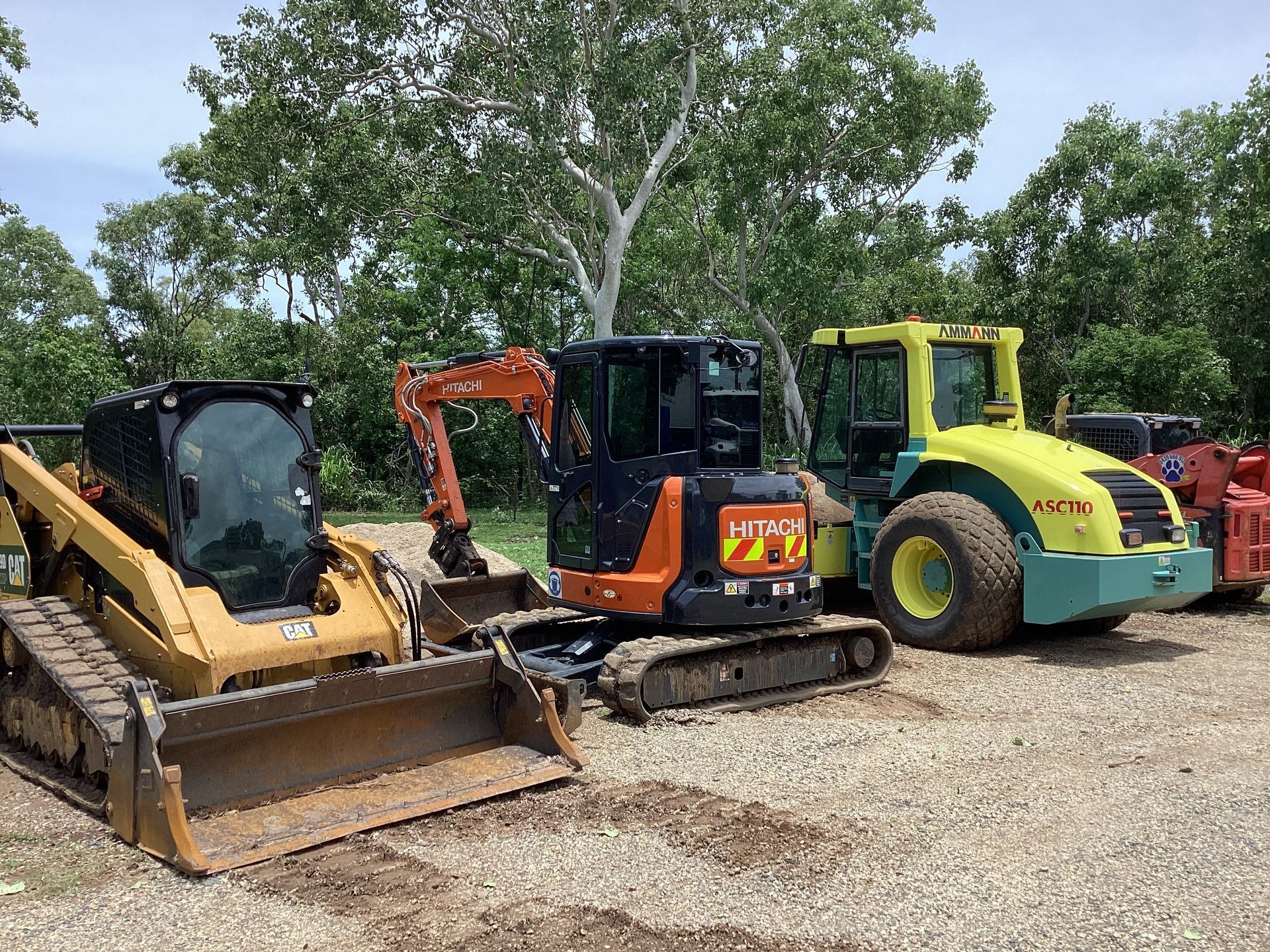 Heavy construction equipment parked outdoors: skid steer, excavator, and soil compactor — Blue Dog Hire Qld In Midge Point, QLD