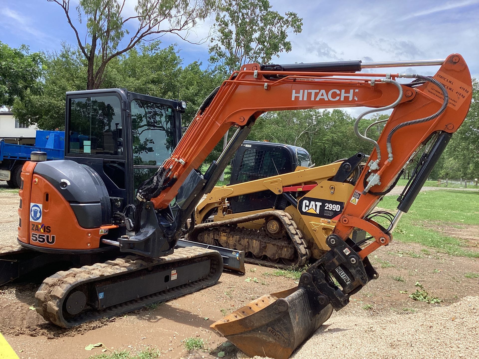 Orange Hitachi excavator and yellow Caterpillar skid steer on a construction site — Blue Dog Hire Qld In Midge Point, QLD