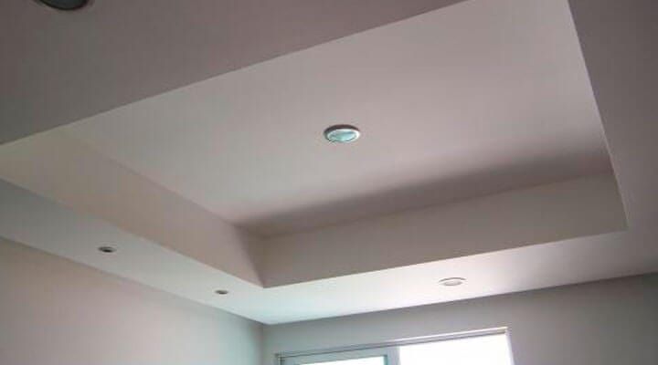 Una habitación con un techo blanco y una ventana.