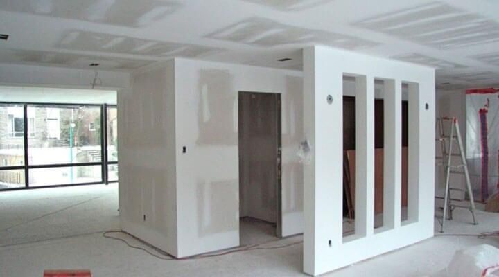 Una habitación que está siendo remodelada con paredes blancas.