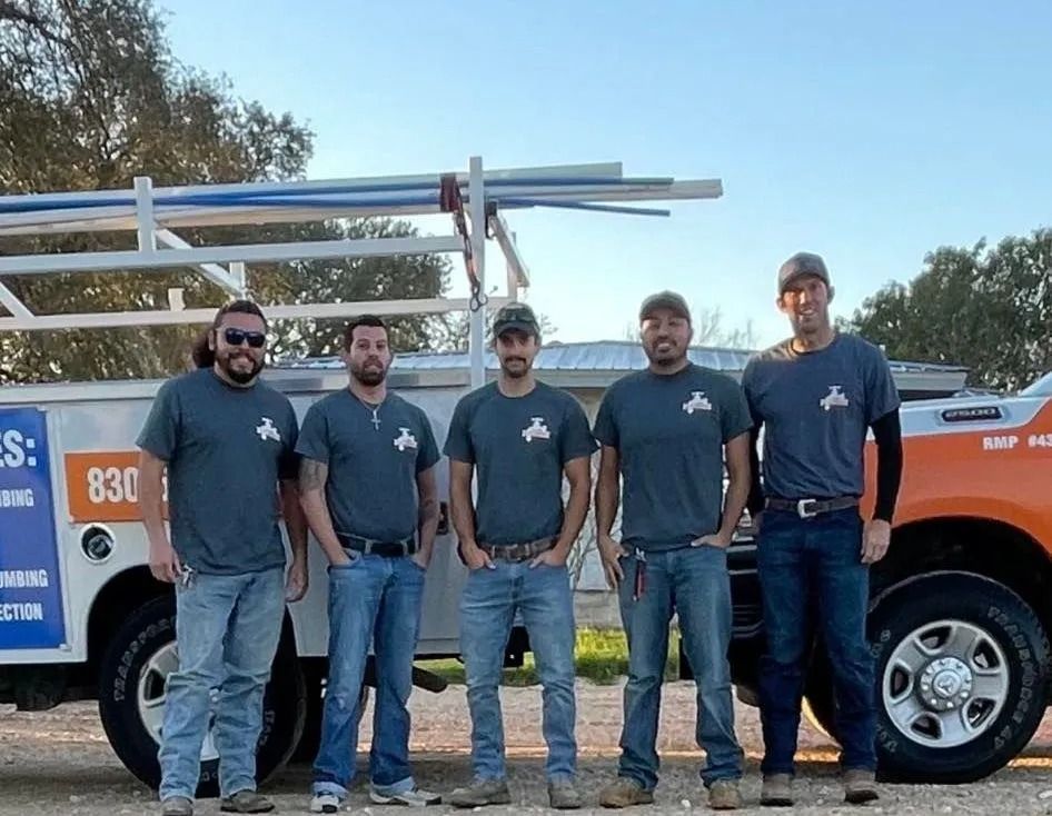 Five workers stand in front of an orange utility truck carrying ladders.
