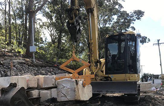 8 1/2 excavator moving quarried sandstone blocks