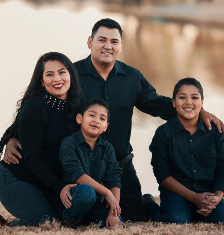 A family is posing for a picture together in a field.