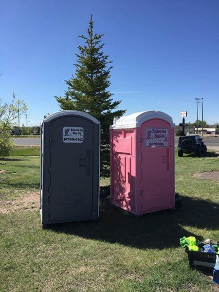 Two Portable Toilets are Sitting Next to Each Other in a Grassy Field | Cheyenne, WY | Toilets On The Go, LLC