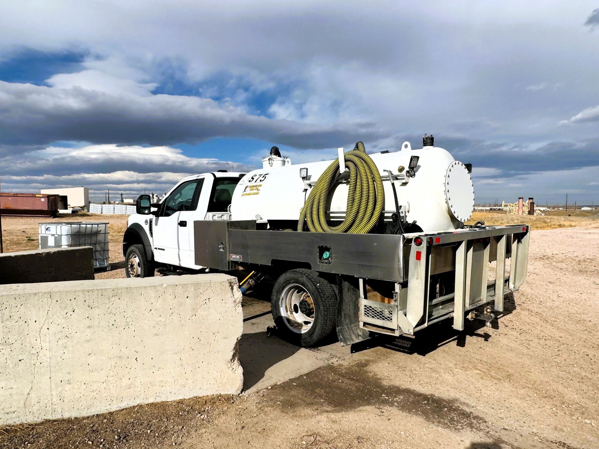 A White Vacuum Truck is Parked in a Dirt Field | Cheyenne, WY | Toilets On The Go, LLC