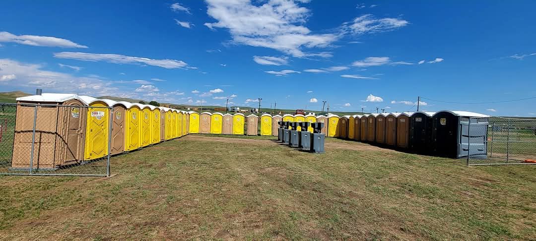 A Row of Yellow Portable Toilets are Lined up in a Field | Cheyenne, WY | Toilets On The Go, LLC