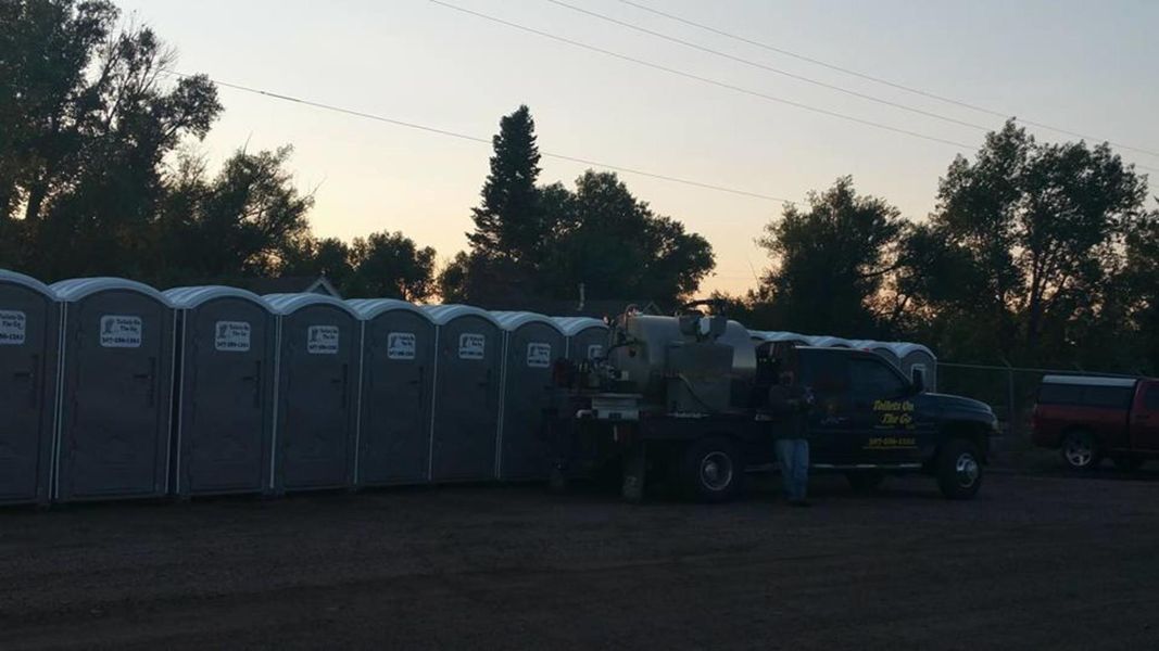 A Row of Portable Toilets are Lined up in a Parking Lot | Cheyenne, WY | Toilets On The Go, LLC