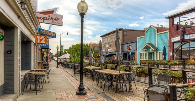 Street scene with outdoor dining, buildings, and a lamp post.