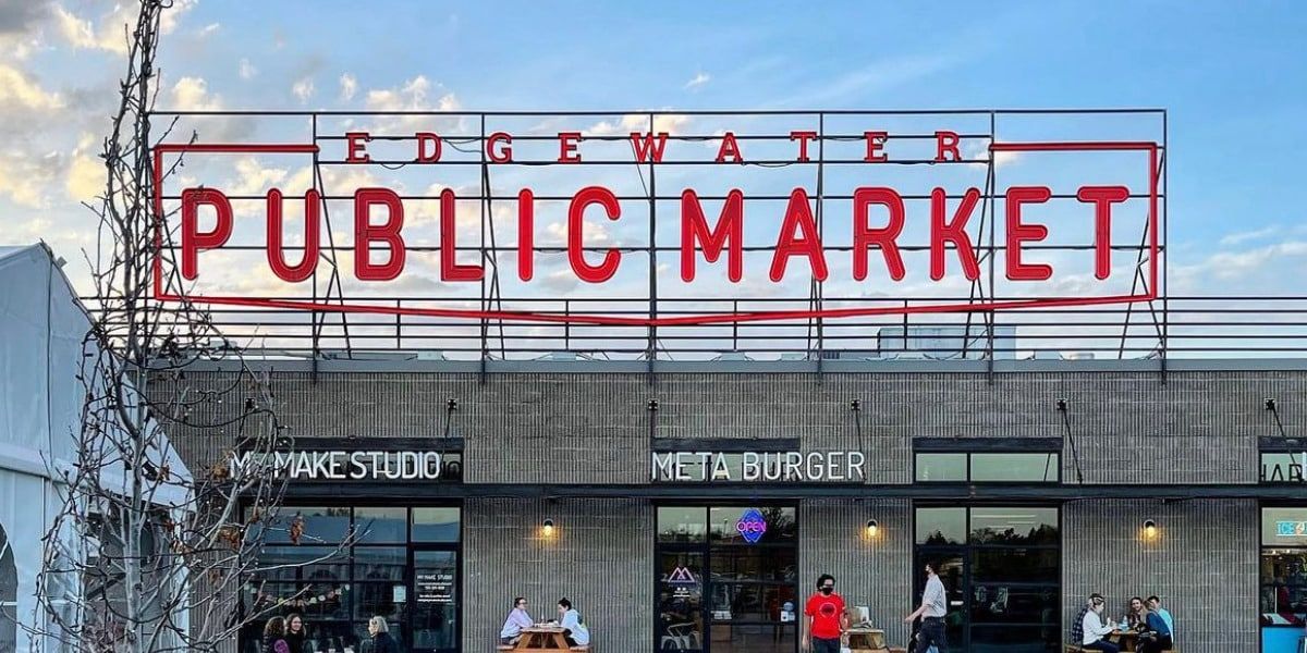Edgewater Public Market sign in red letters atop a modern building with people.