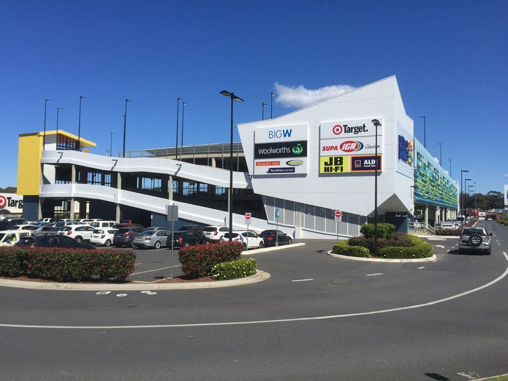 Shopping Centre Parking Lot View With Business Logos — Acheson Building Certification In Coffs Harbour NSW