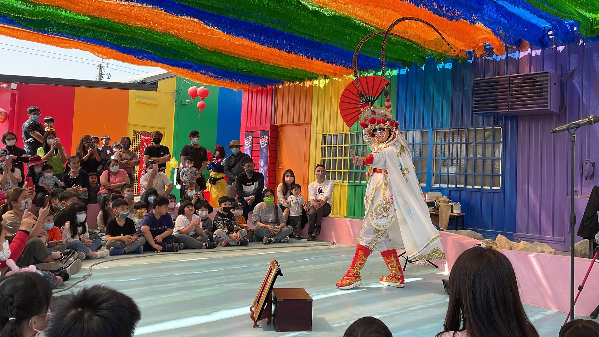 A group of people are sitting in front of a stage watching a performance.