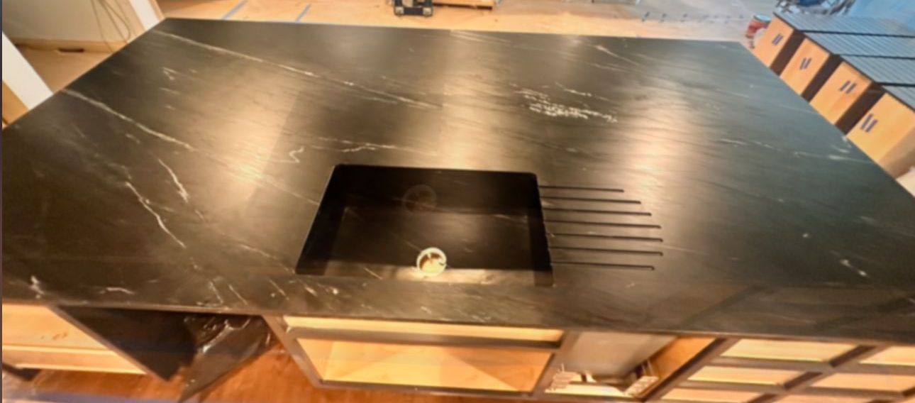 Dark Soap stone countertop with integrated drainboard