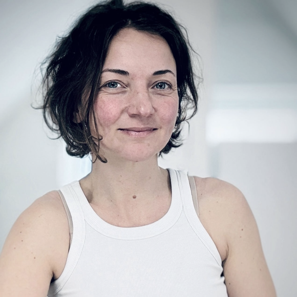 Nahaufnahme einer Frau mit blauen Augen und einem schwarzen Hemd