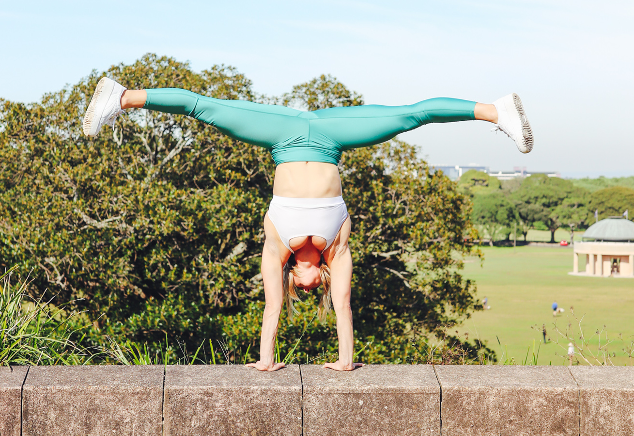 Image of a girl doing a handstand in the park