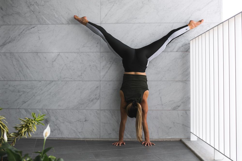 Image of a girl doing a handstand in her apartment