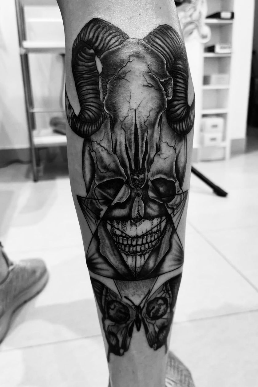 Une photo en noir et blanc d'un tatouage représentant un crâne avec des cornes