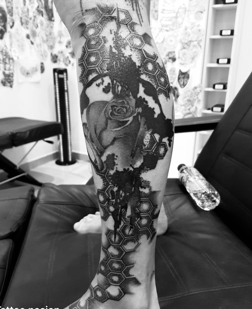 Une photo en noir et blanc d’une personne avec un tatouage sur la jambe.