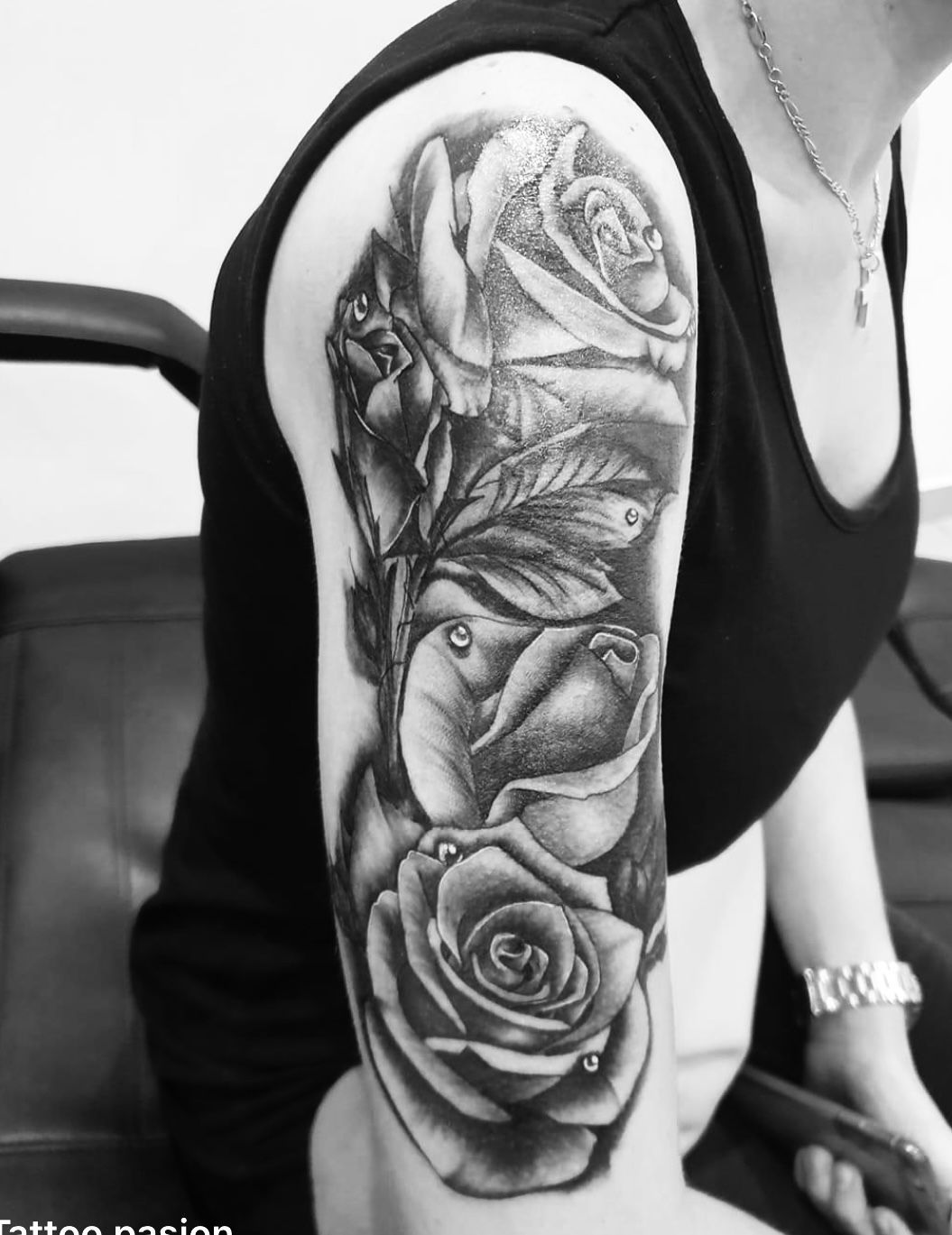 Une femme a un tatouage de trois roses sur son bras
