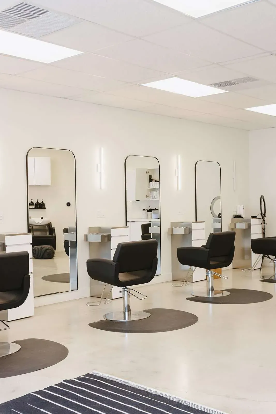 A hair salon with a lot of chairs and mirrors.