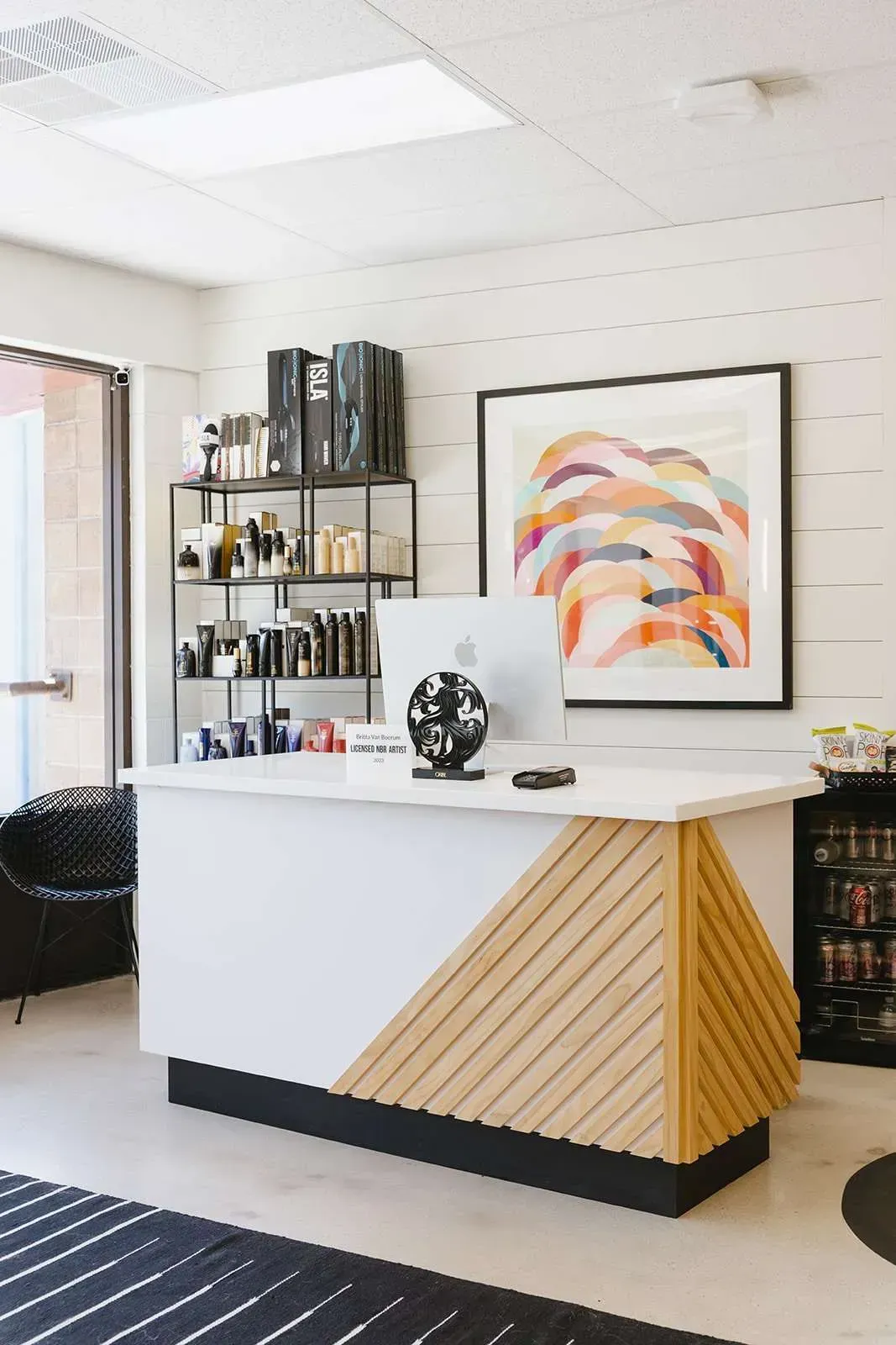 A reception desk in a salon with a computer on it.