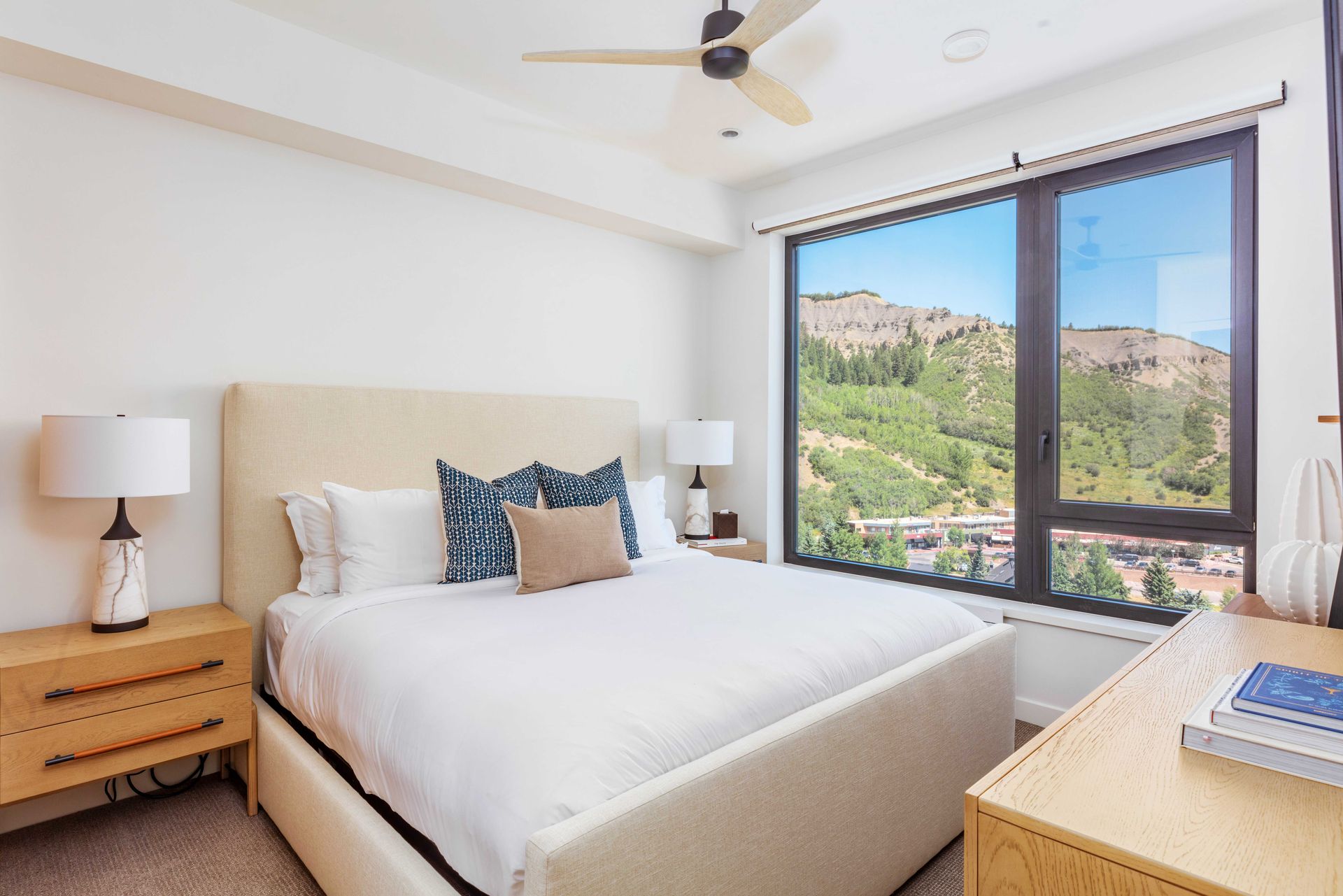 A bedroom with a large bed and a large window.