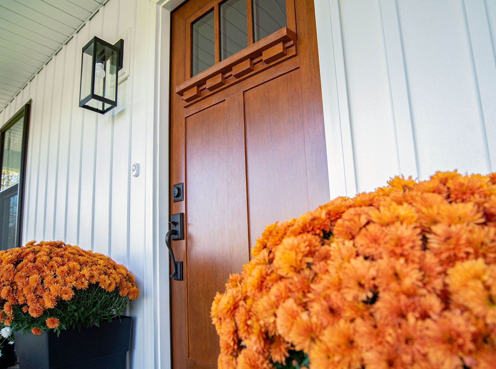 The front door of a house with flowers in front of it.