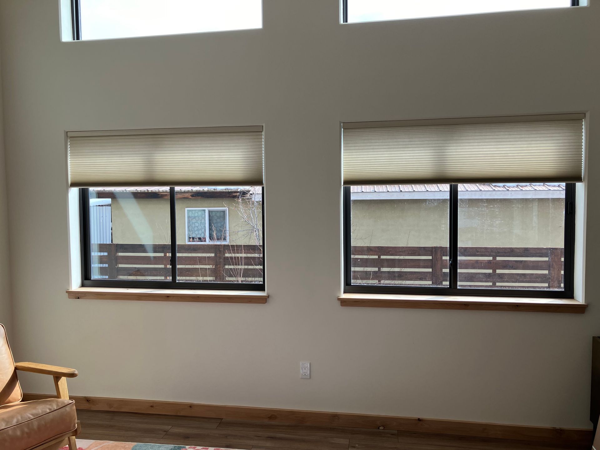 A living room with two windows and a chair
