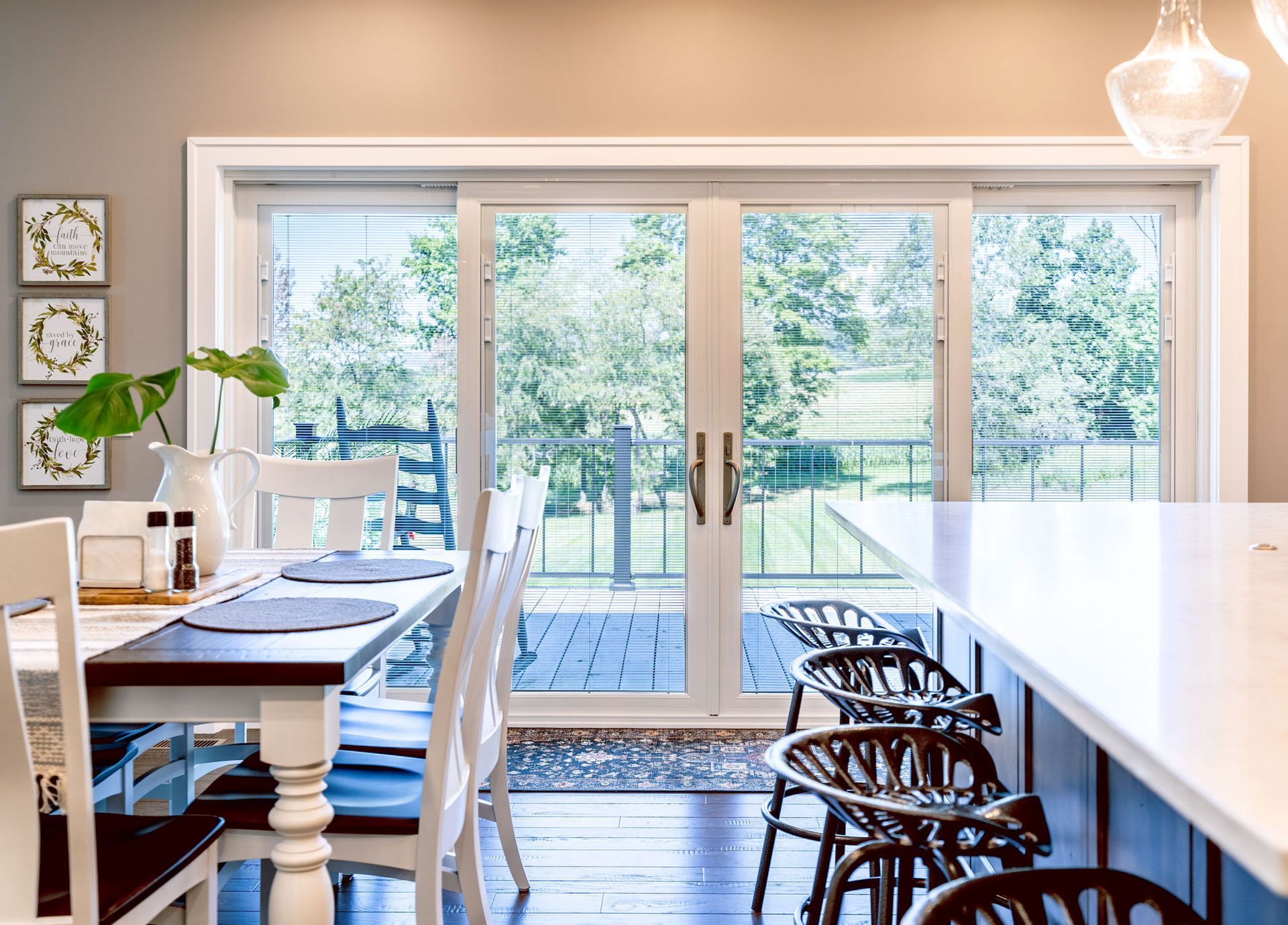A dining room with a table and chairs and sliding glass doors leading to a deck.