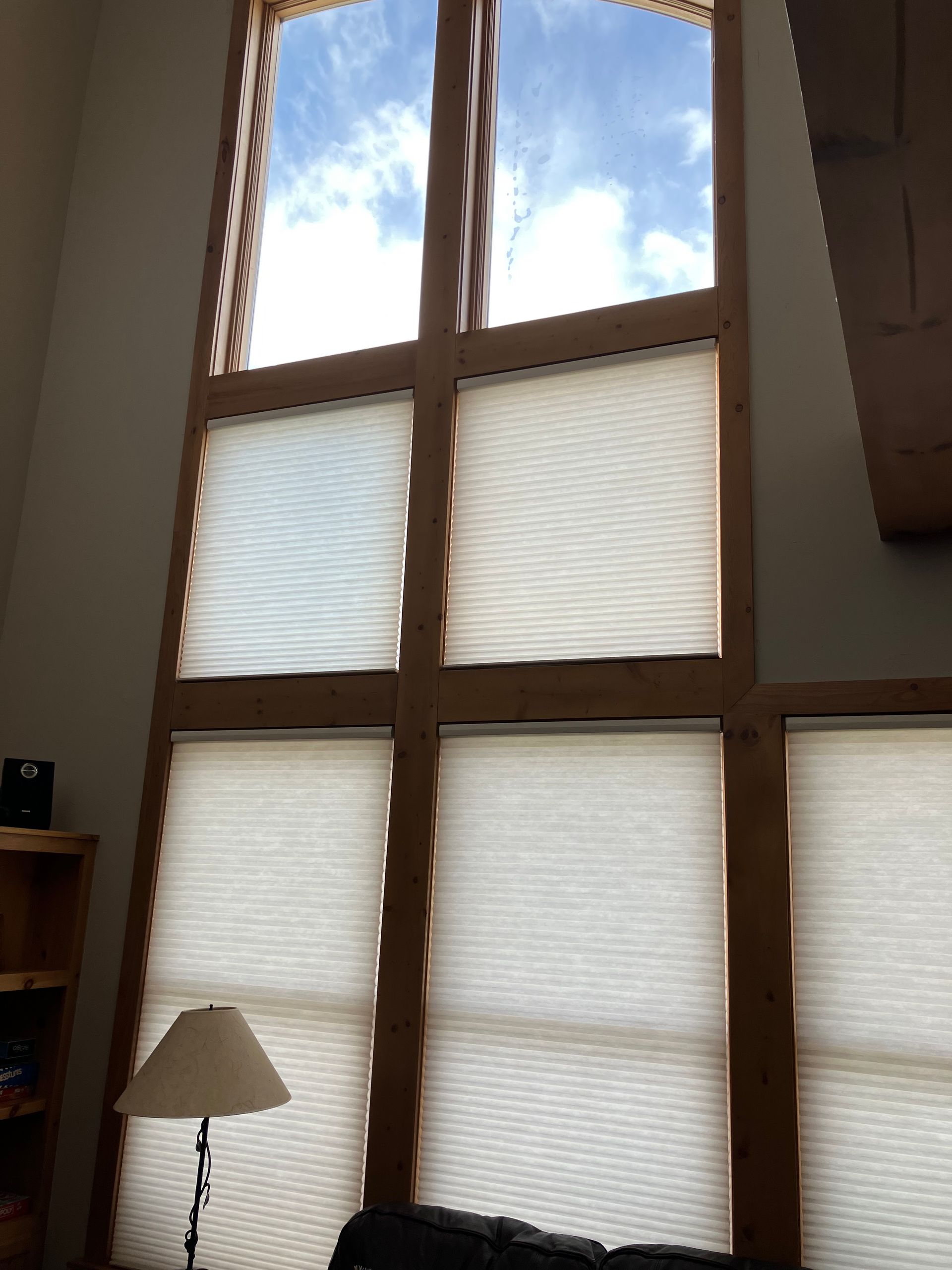 A living room with a large window and a lamp