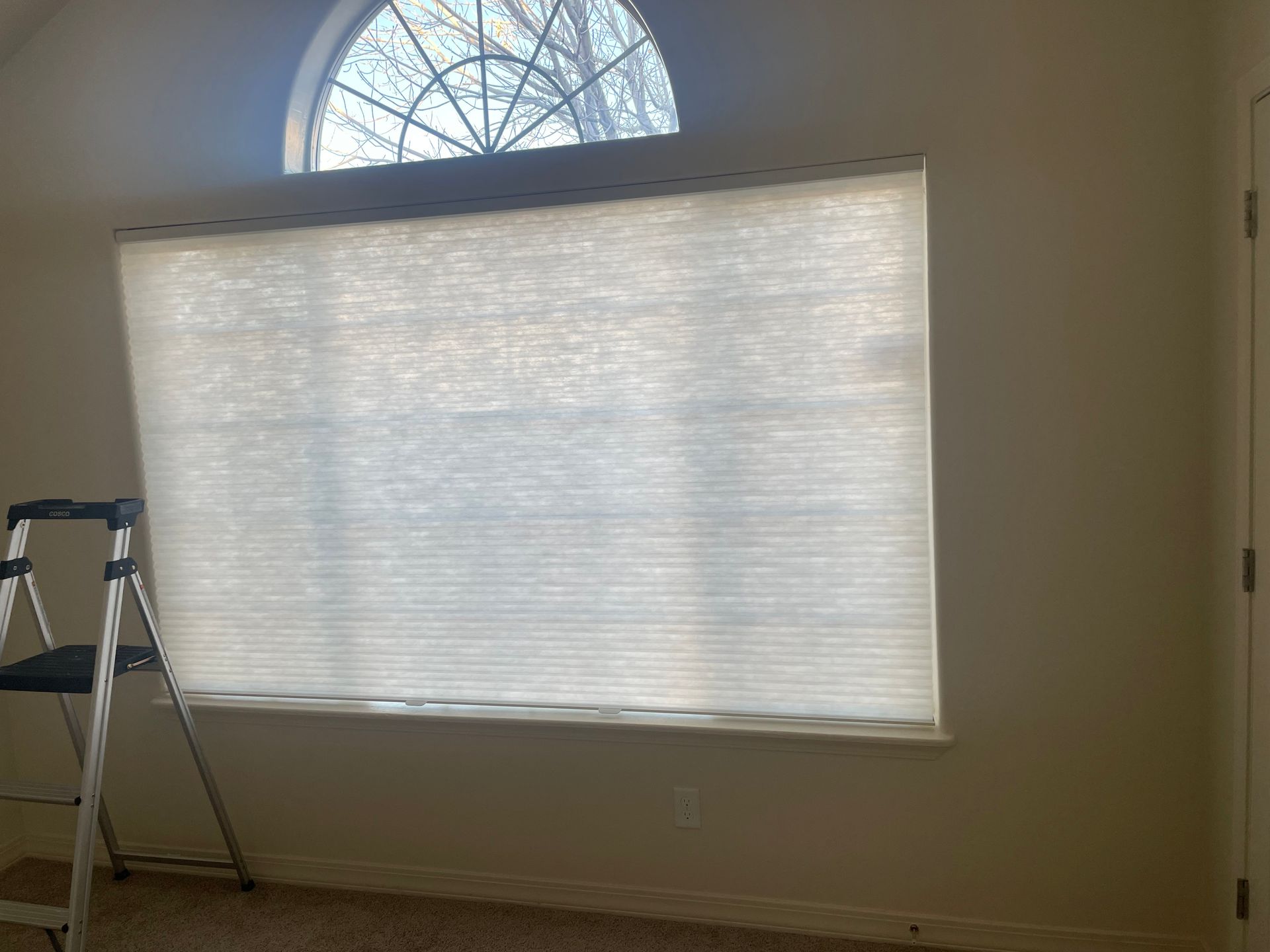 A room with a window and a ladder in it.