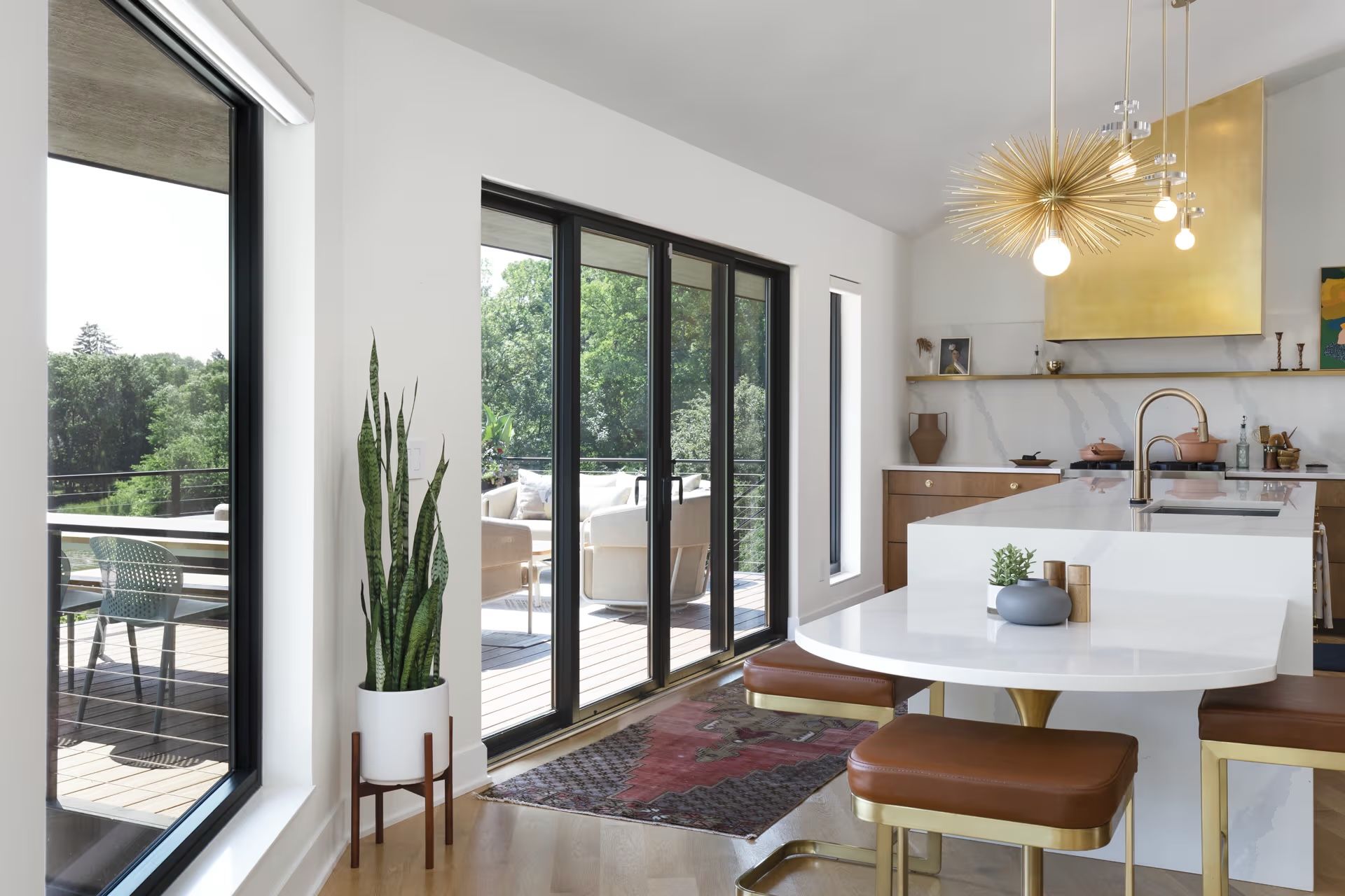 A kitchen with a table and stools and a large window.