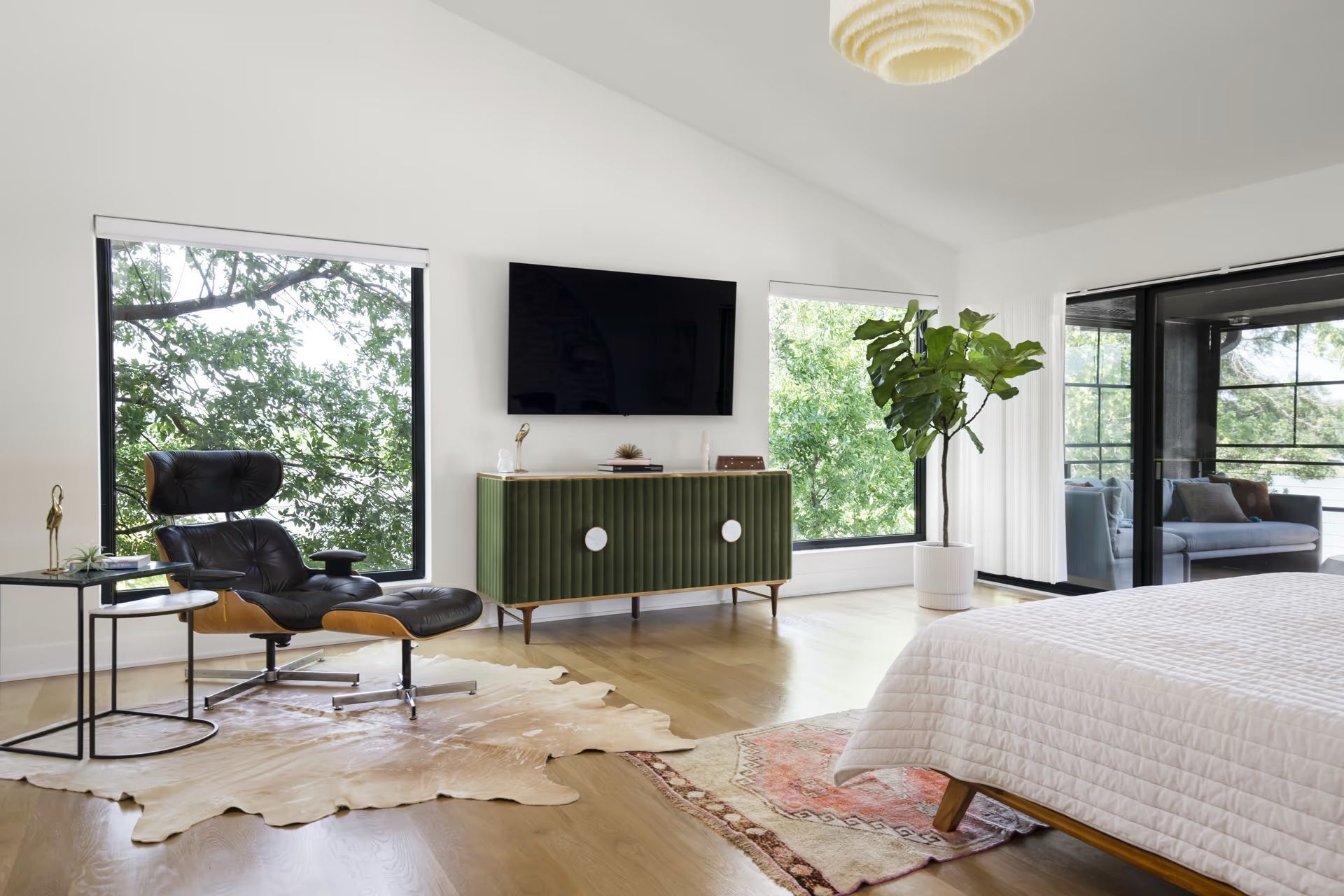 A bedroom with a large bed , a chair , a television and a rug.