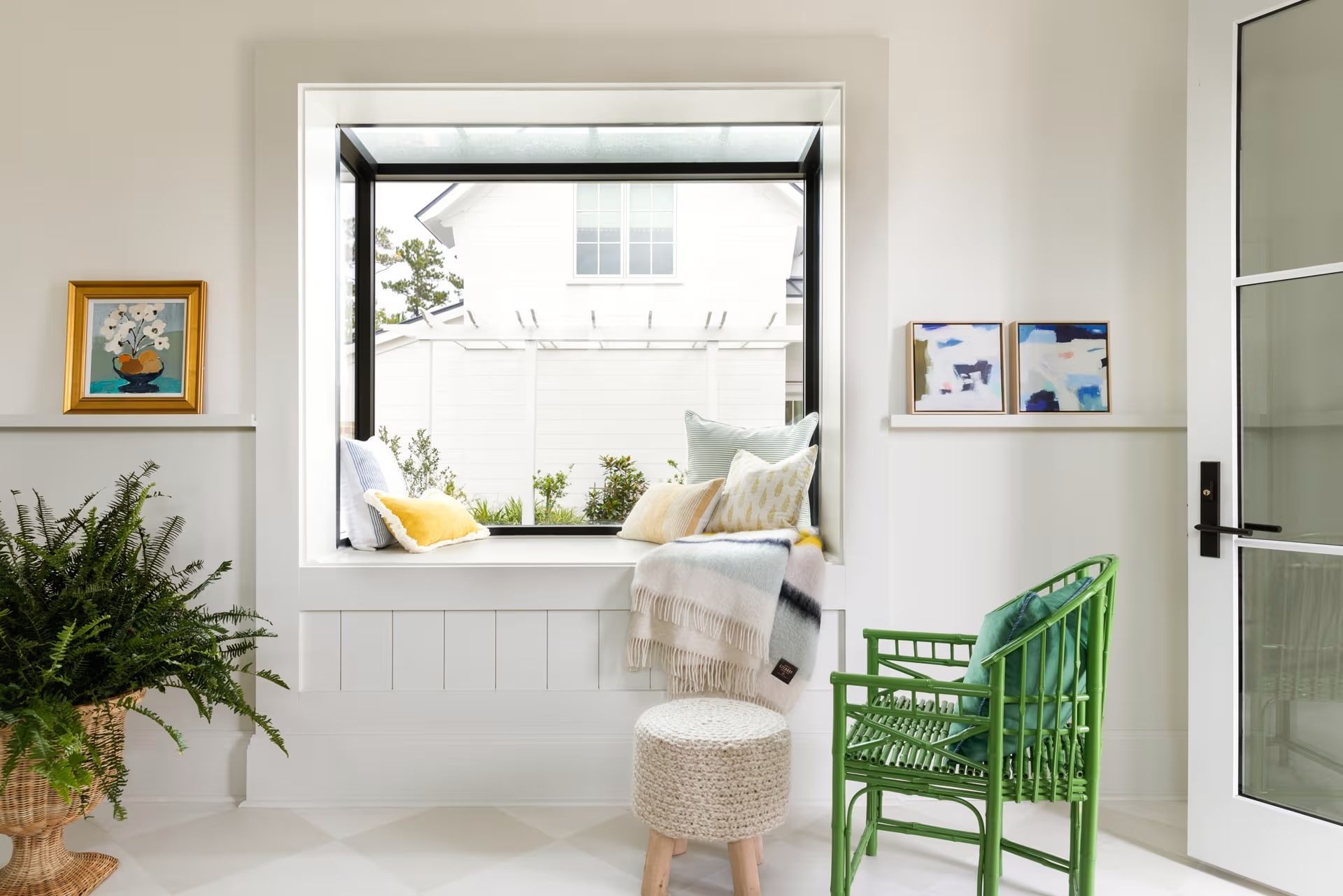 A living room with a window seat and a green chair.