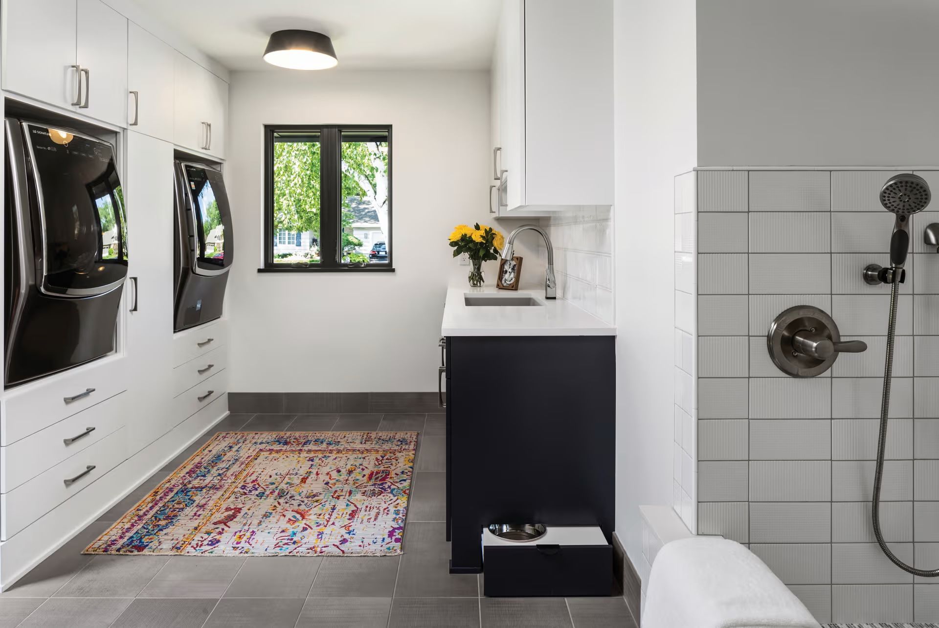 A laundry room with a washer and dryer and a shower.